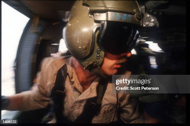 Army Airborne Ranger flies in a helicopter October 13, 1993 in Mogadishu, Somalia. Two US Army Airborne Ranger''s helicopters were shot down October...