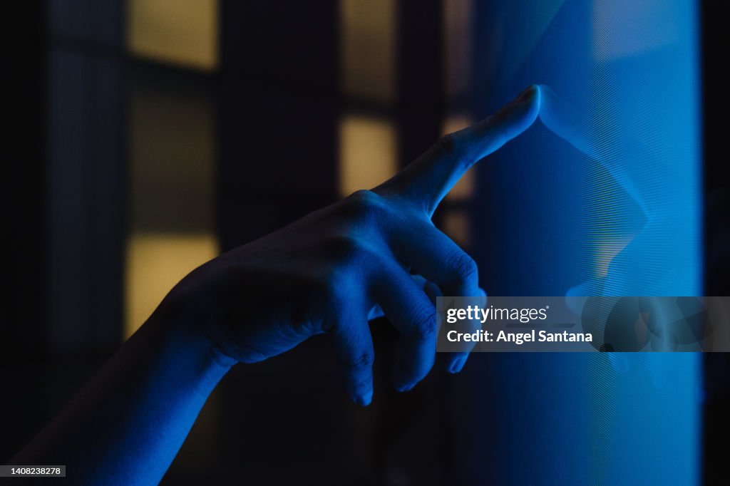 Close up view of woman hand using interactive touchscreen display of electronic kiosk