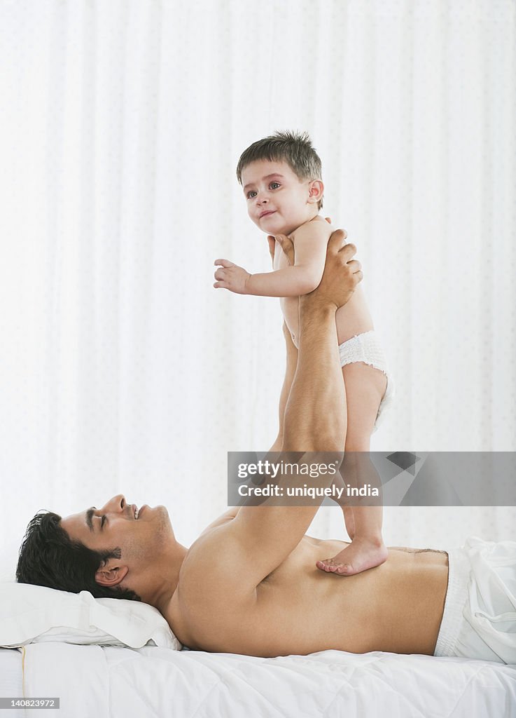 Man playing with his daughter on the bed