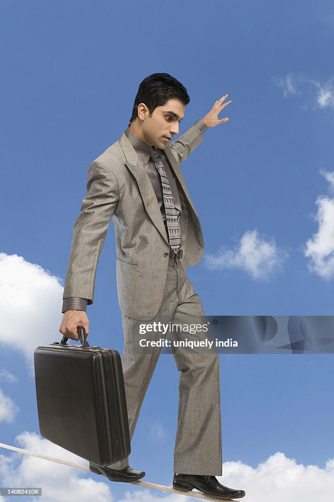 Businessman walking on tightrope