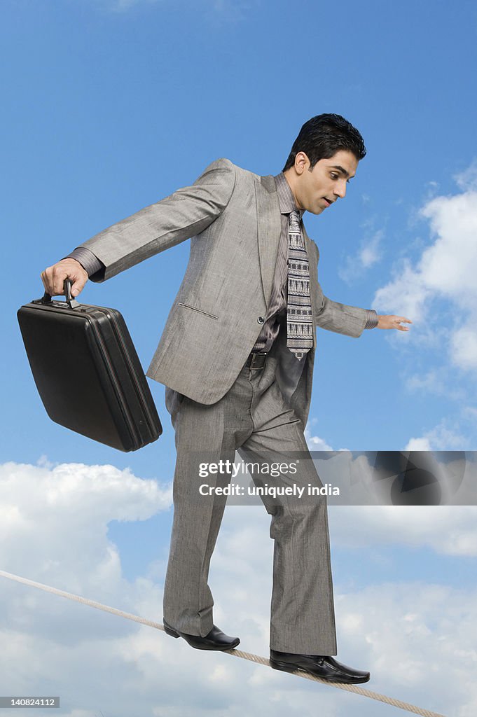 Businessman walking on tightrope