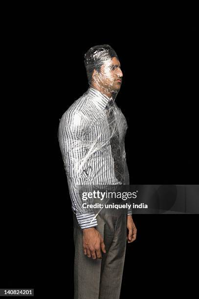 businessman wrapped in a plastic wrap - man wrapped in plastic stock pictures, royalty-free photos & images