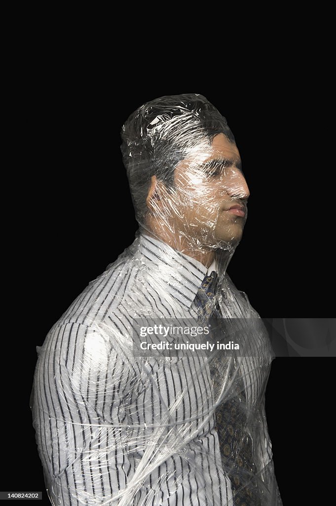 Businessman wrapped in a plastic wrap