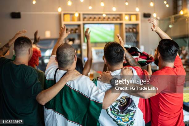 mexican fans celebrating a goal in soccer game at bar - international soccer event stock pictures, royalty-free photos & images