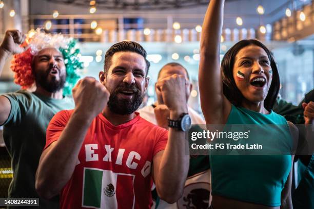 mexican fans celebrating a goal in soccer game at bar - mexico soccer bildbanksfoton och bilder