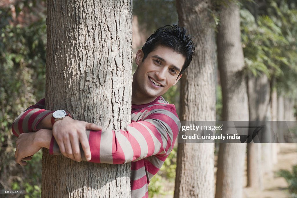 Portrait of a man hugging a tree