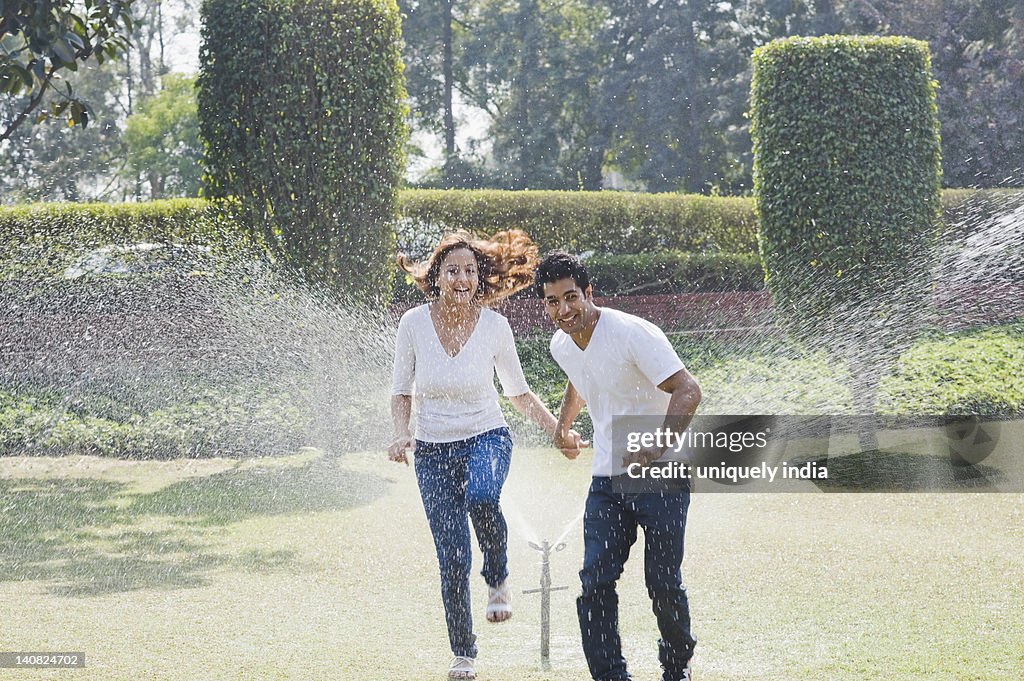 Couple enjoying near a sprinkler, Gurgaon, Haryana, India