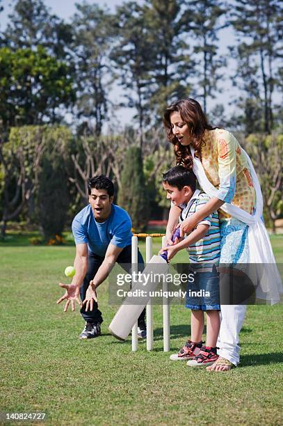 couple playing cricket with their son, gurgaon, haryana, india - cricket ball stockfoto's en -beelden