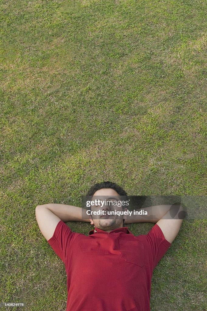Man lying in a lawn and smiling
