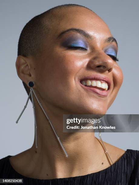 portrait happy, carefree young woman with dangling earrings - femme make up mauve photos et images de collection