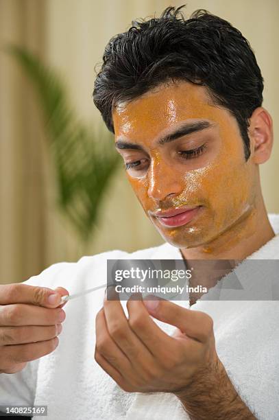 close-up of a man with peel off mask filing his nails - peel off mask stock-fotos und bilder