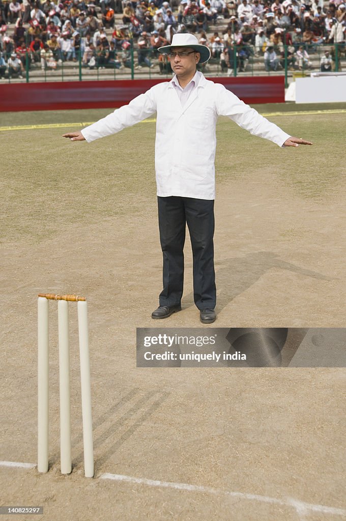 Cricket umpire signaling Wide Ball