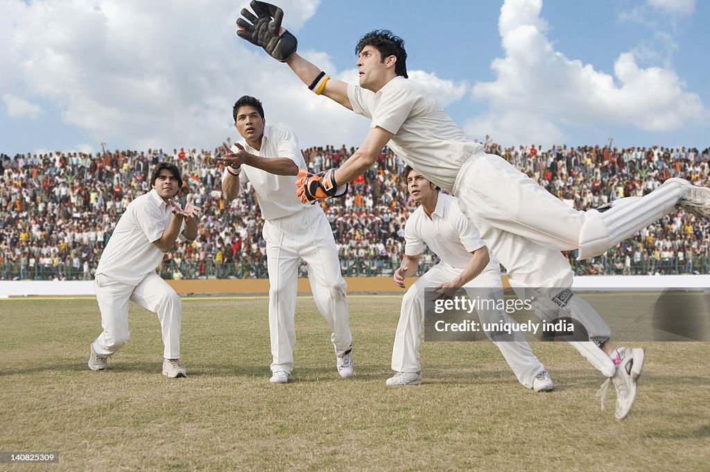 Cricket wicket keeper and fielders attempting for a catch