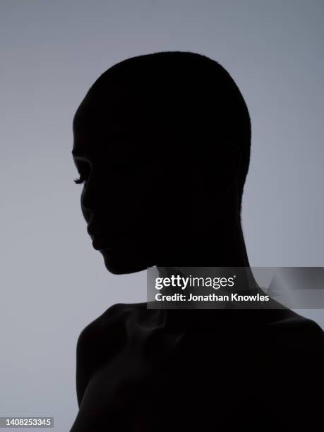 silhouetted profile woman with shaved head - woman profile stock pictures, royalty-free photos & images