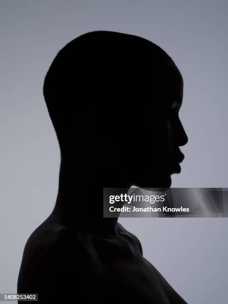 silhouetted profile of woman with shaved head - black woman in silhouette stock pictures, royalty-free photos & images