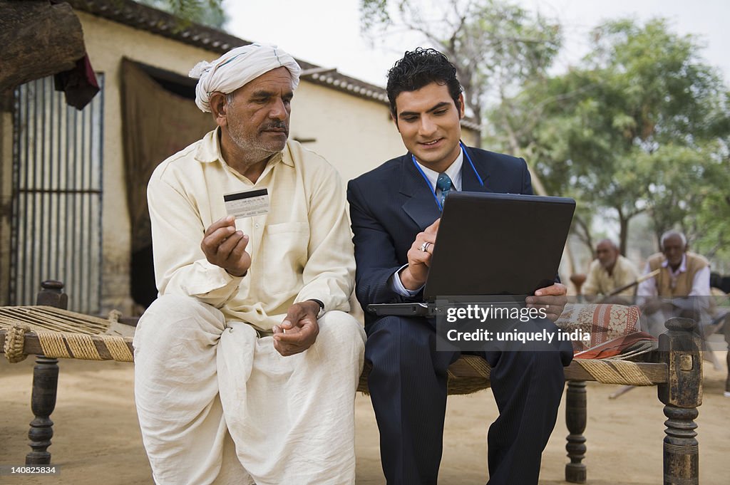 Financial advisor explaining to a farmer about agriculture loan, Hasanpur, Haryana, India