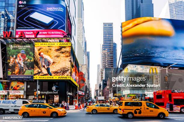 times square with commercial ads and heavy traffic on a sunny day, new york city, usa - times square new york stock-fotos und bilder