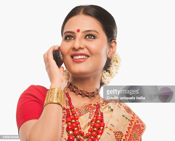 close-up of a woman talking on a mobile phone in traditional clothing - bihu stock pictures, royalty-free photos & images