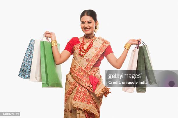portrait of a woman holding shopping bags on bihu festival - bihu stock pictures, royalty-free photos & images