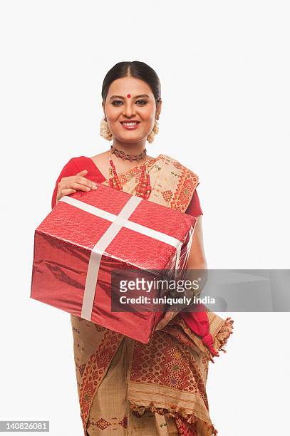portrait of a woman holding a present on bihu festival - bihu stock pictures, royalty-free photos & images
