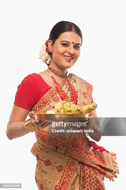 portrait of a woman holding a plate of religious offerings on bihu festival - bihu fotografías e imágenes de stock