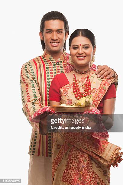 portrait of a couple holding a plate of religious offerings - bihu stock pictures, royalty-free photos & images