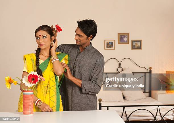 man putting flower in his wife's hair - bengali culture stock pictures, royalty-free photos & images