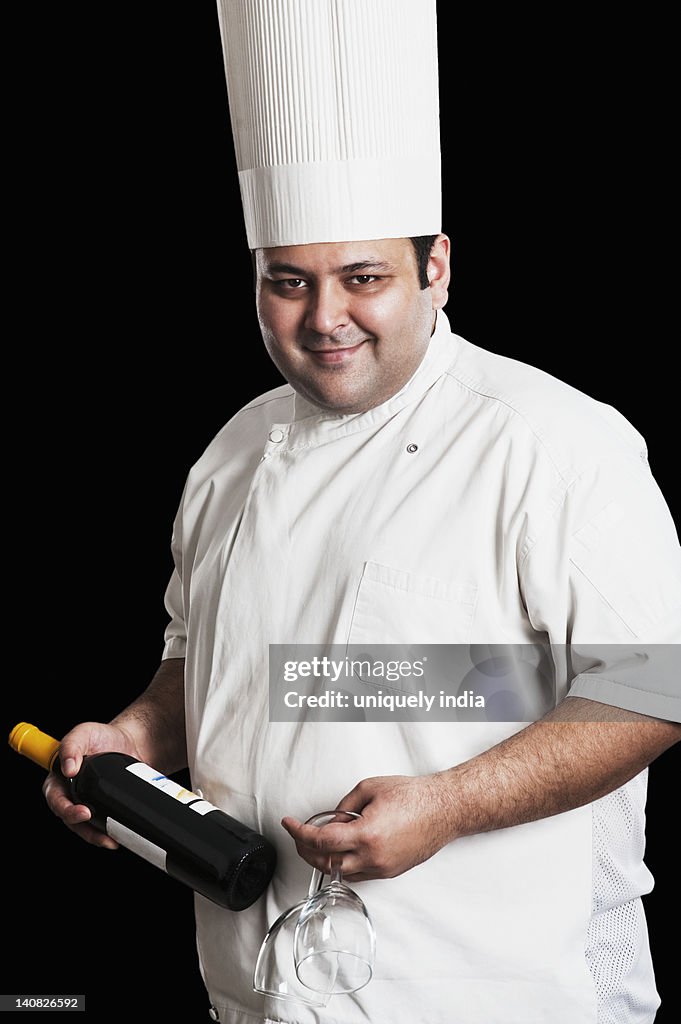 Chef holding wine bottle and wineglasses