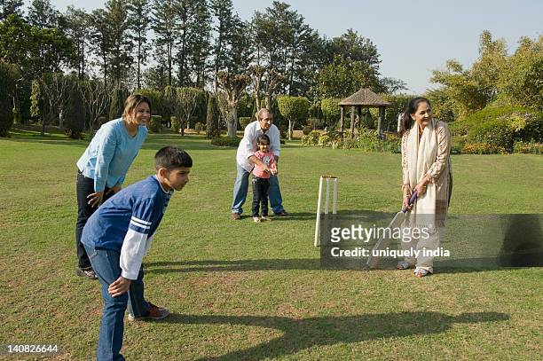 family playing cricket in lawn - mom flirting stockfoto's en -beelden