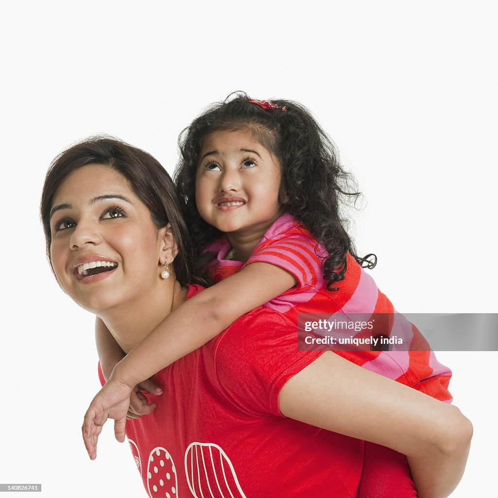 Woman giving piggyback ride to her daughter