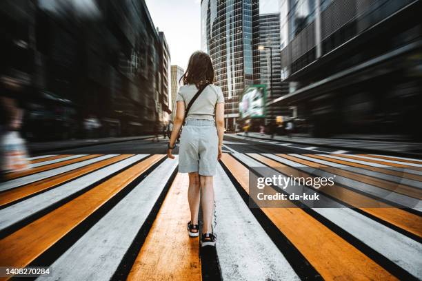 girl stands in the middle of the city street in downtown - youth culture speed stock pictures, royalty-free photos & images