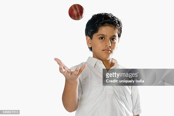 boy tossing a cricket ball - cricket player white background stock-fotos und bilder