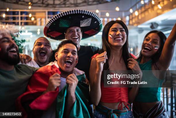 mexican fans celebrating a goal in soccer game at bar - sombrero stock pictures, royalty-free photos & images