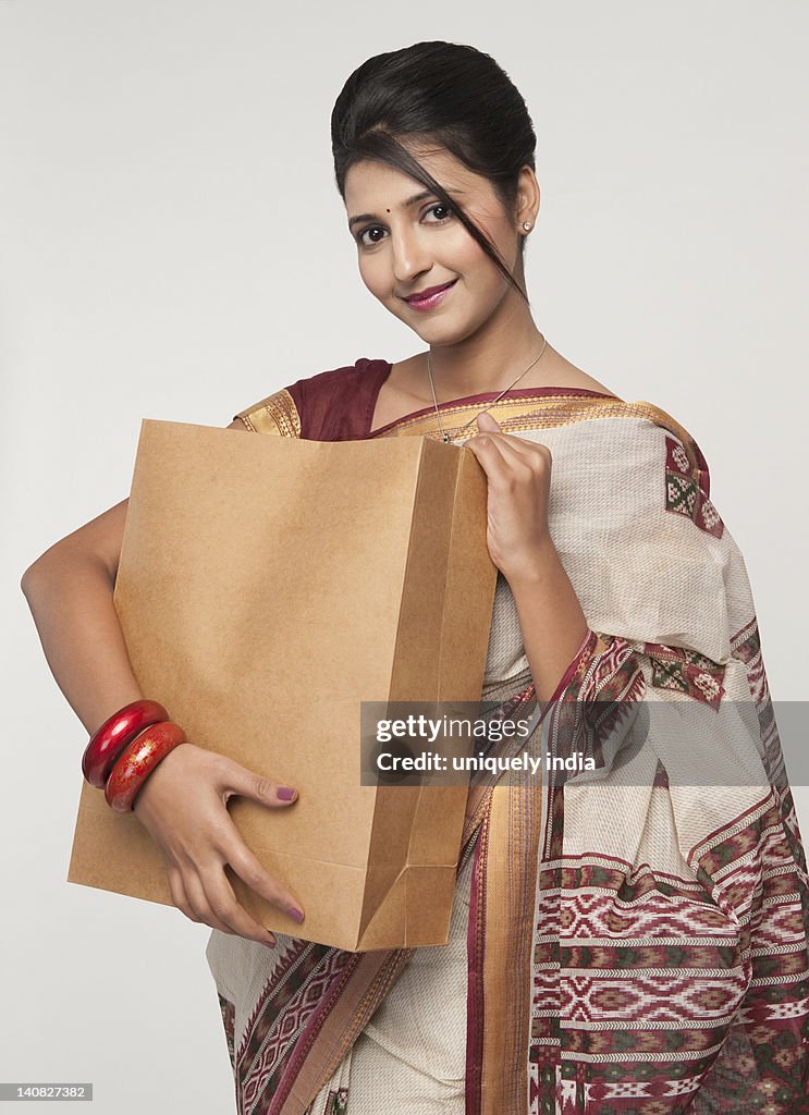 Portrait of a woman holding a shopping bag and smiling