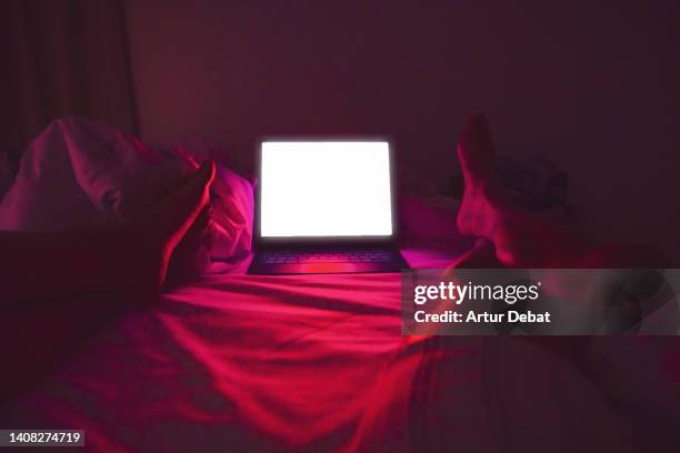 watching series using streaming platform with laptop in the bed at home. - apple tv fotografías e imágenes de stock