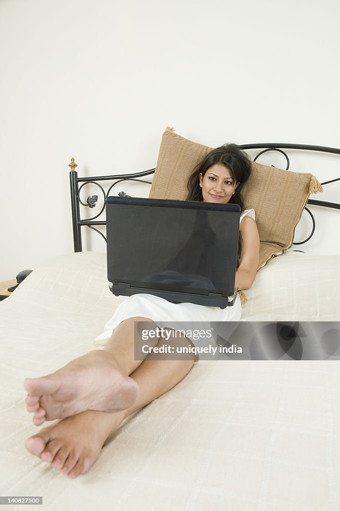 Woman using a laptop on the bed