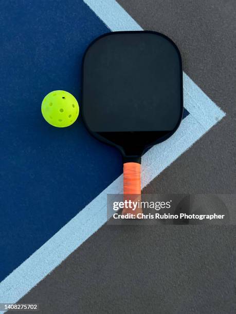 pickleball paddle and ball on a court - paddle stock-fotos und bilder