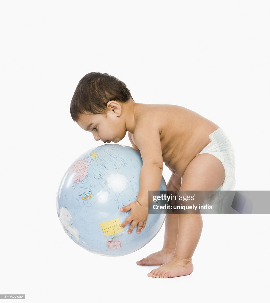 Baby boy playing with a globe