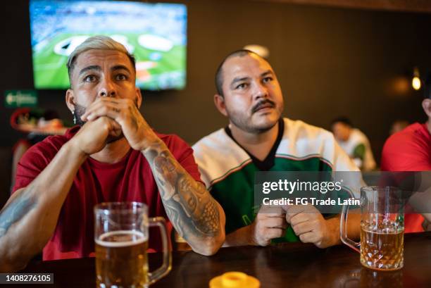 freunde, die in der bar sport schauen - mexican beer stock-fotos und bilder