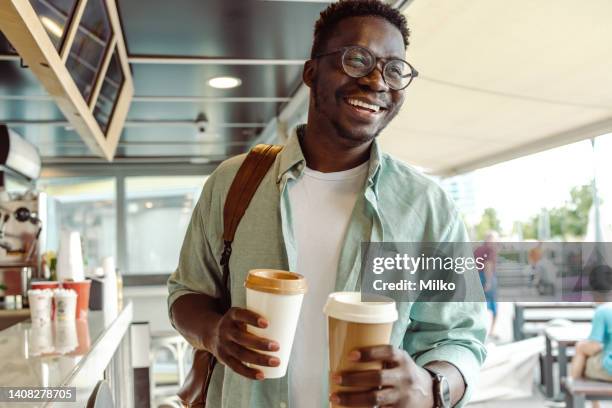 african-american student picking up a coffee - morning coffee stock pictures, royalty-free photos & images