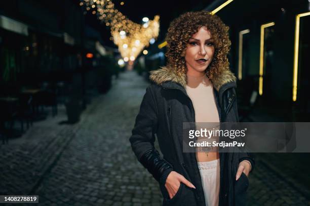 portrait of young caucasian woman in halloween costume standing on the city street at night - lion costume stock pictures, royalty-free photos & images