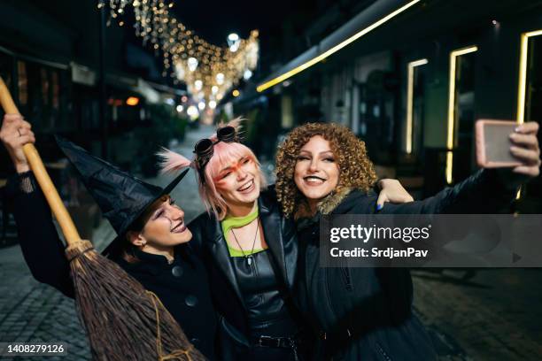 tres mujeres jóvenes disfrazadas de haloween haciendo selfies en la calle de la ciudad - disfraz fotografías e imágenes de stock