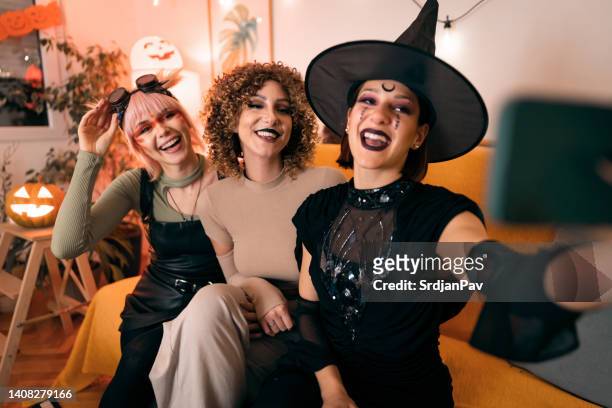 three young women taking selfies at halloween party - halloween party imagens e fotografias de stock