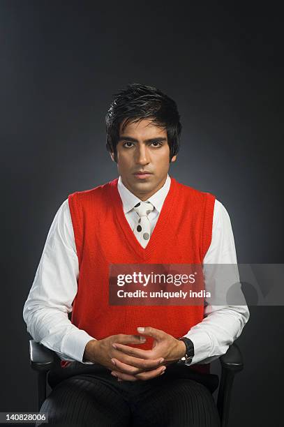 portrait of a businessman sitting on a chair - sweatervest stock pictures, royalty-free photos & images
