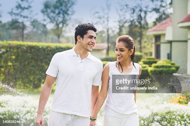couple walking in a garden - young couple holding hands stock pictures, royalty-free photos & images
