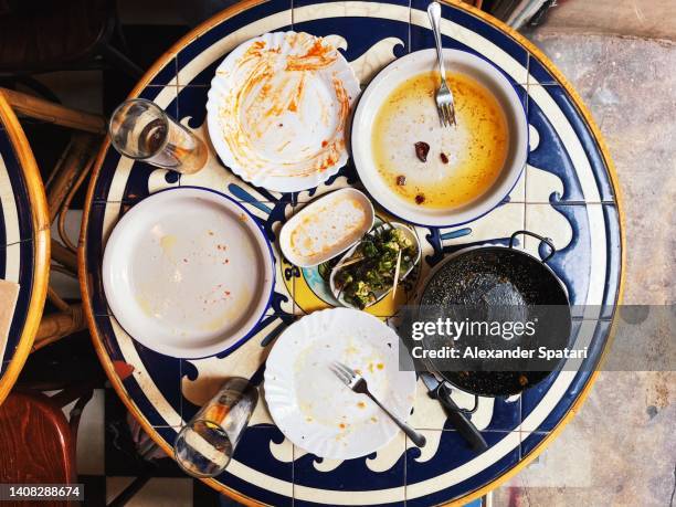 dirty plates on the table after dinner in the restaurant - wash the dishes stockfoto's en -beelden