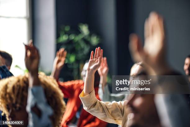 grupo de personas anónimas levantando la mano en un seminario - personas reunidas fotografías e imágenes de stock