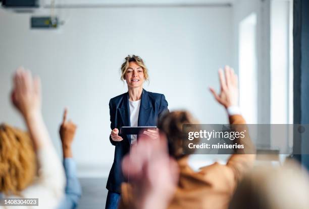 cheerful female presenter interacting with the audience - palestrante imagens e fotografias de stock
