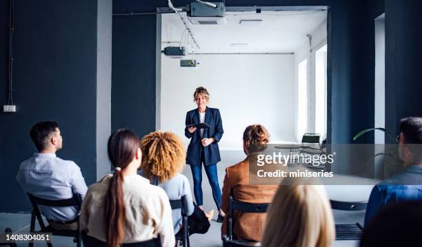 cheerful female presenter interacting with the audience - bemiddeling stockfoto's en -beelden