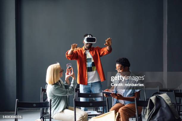 students having fun while playing in virtual reality goggles in the classroom - virtual reality classroom stock pictures, royalty-free photos & images